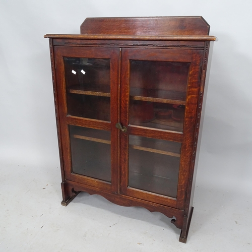 2273 - A 1930s oak bookcase with raised back and two glazed doors. 77cm x 104 cm x 27cm