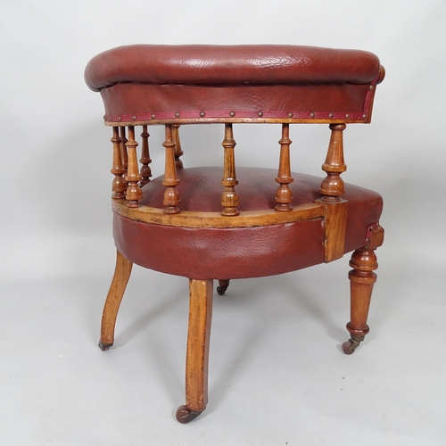 2509 - An early 20th century mahogany and red faux-leather upholstered bow arm desk chair