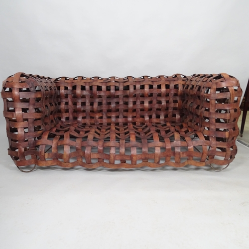 2513 - A mid-century sculptural woven leather strap sofa, the leather straps supported on welded steel fram... 