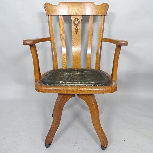 2525 - An oak and leather upholstered swivel desk chair