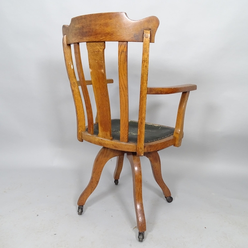 2525 - An oak and leather upholstered swivel desk chair