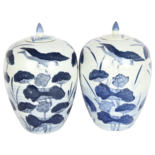 167 - A pair of large Chinese design blue and white vases and covers, with lily decoration, height 33cm