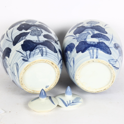 167 - A pair of large Chinese design blue and white vases and covers, with lily decoration, height 33cm