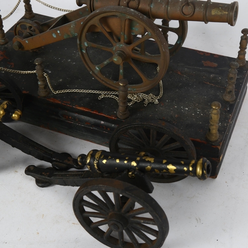 190 - A brass model cannon on wood base, length 31cm, and a pair of smaller painted brass model cannons