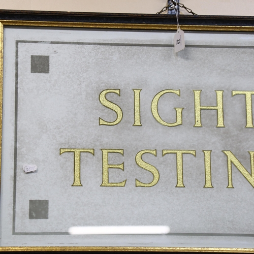 35 - A gilded glass Optician's Testing sign, framed, overall 53cm x 80cm