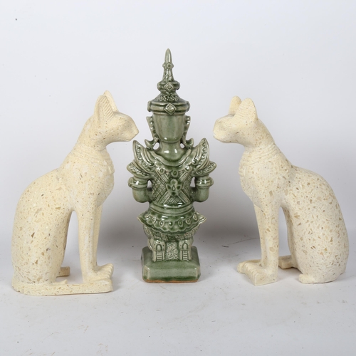 44 - A Thai celadon glaze pottery temple figure, height 40cm, and a pair of granite Bastet figures (3)