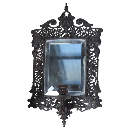 98 - A pierced and engraved cast-metal bevel-edge wall mirror, with single sconce and decorated with drag... 