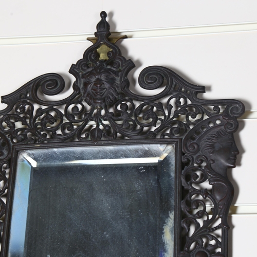 98 - A pierced and engraved cast-metal bevel-edge wall mirror, with single sconce and decorated with drag... 