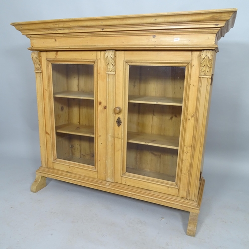 2538 - A vintage pine bookcase with two fixed shelves and two glazed doors. 114cm x 103cm x 41cm