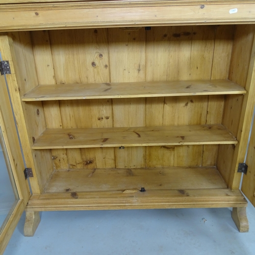 2538 - A vintage pine bookcase with two fixed shelves and two glazed doors. 114cm x 103cm x 41cm