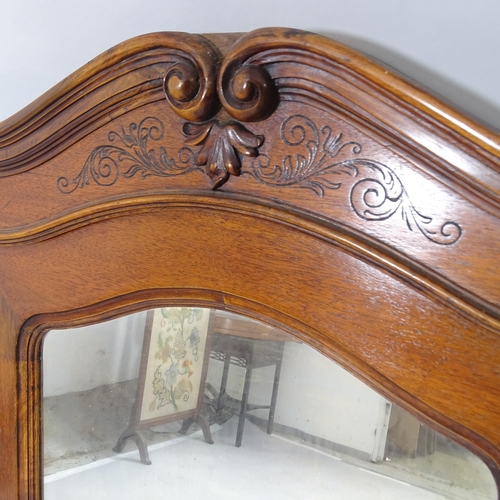 2552 - An oak arch top over-mantle mirror with carved decoration. 104cm x 116cm