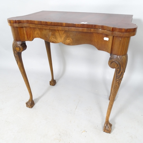 2571 - A reproduction oak fold-over card table raised on cabriole legs, with claw and ball feet. 76cm x 75c... 