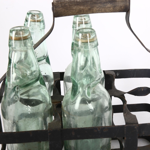 267 - A Vintage bottle carrier with 4 codd-neck bottles with glass marbles, all bottles marked with maker'... 