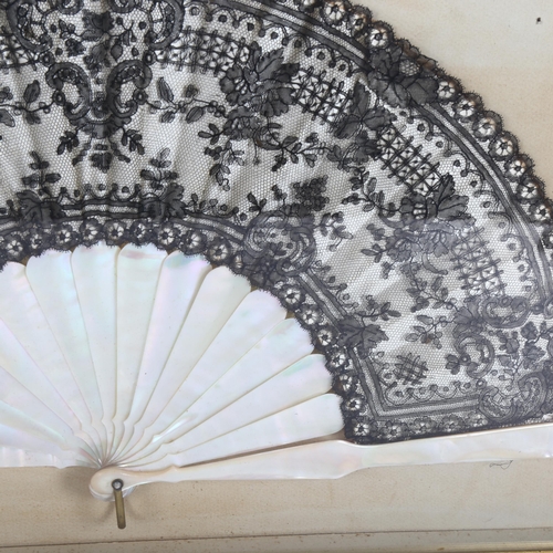 280 - A decorative Oriental style fan, lace panelled with mother-of-pearl spines, in a display case, lengt... 