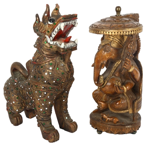 310 - A carved wood figure of Ganesha and a carved wood figure of a foo dog, largest 29cm (2)