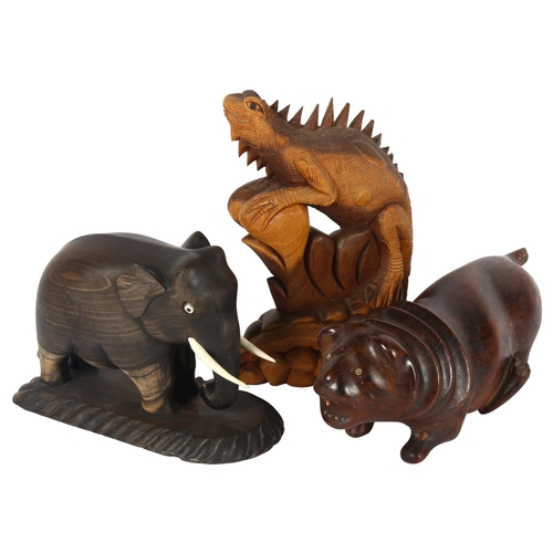 320 - An ebony carved wood Indian elephant, with plastic tusks and eyes, a hardwood carving of a lion, and... 