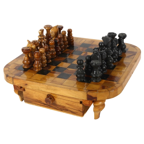 325 - A turned olive wood chess set with fitted drawers underneath chess board, board 28cm square, King he... 