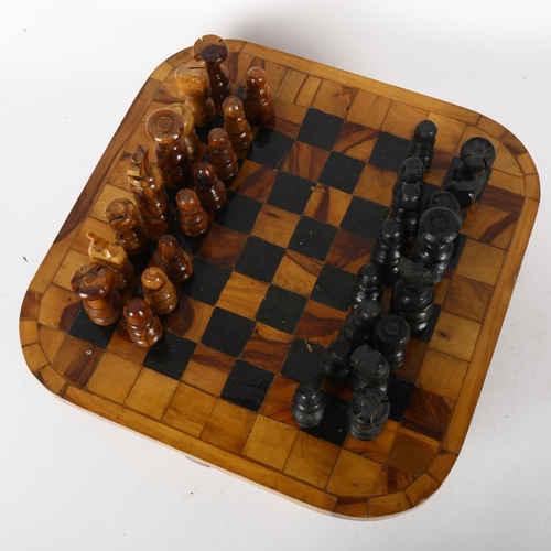 325 - A turned olive wood chess set with fitted drawers underneath chess board, board 28cm square, King he... 