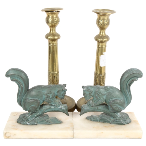 458 - A pair of verdigris metal squirrels on plinths, and a pair of embossed brass candlesticks, 25cm