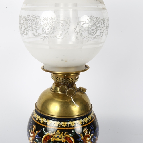 532 - An Antique Maiolica and brass-mounted oil lamp, the font decorated with Bacchanalian scenes, complet... 