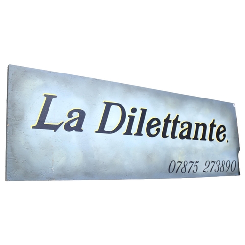 654 - A large sign painted on panel, La Dilettante, 58cm x 172cm