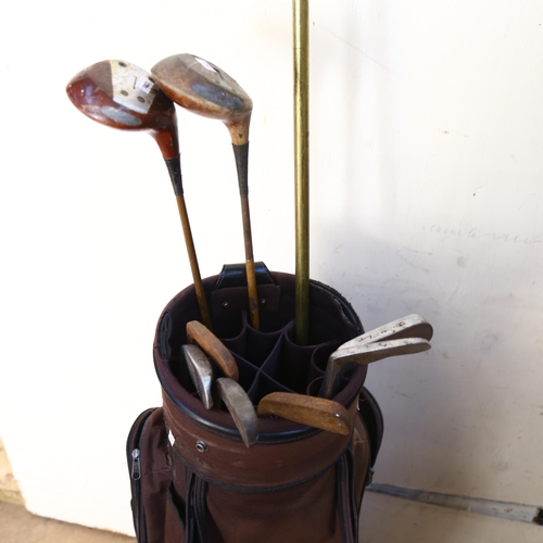 661 - Wooden shafted golf clubs in bag, and a brass and turned wood window winder