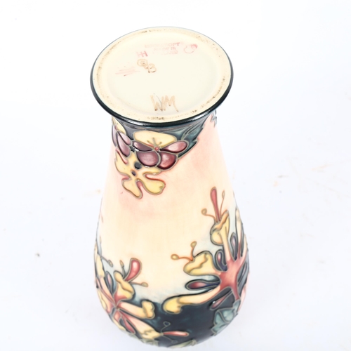 681 - A Moorcroft tube-lined baluster vase with floral design, 20cm