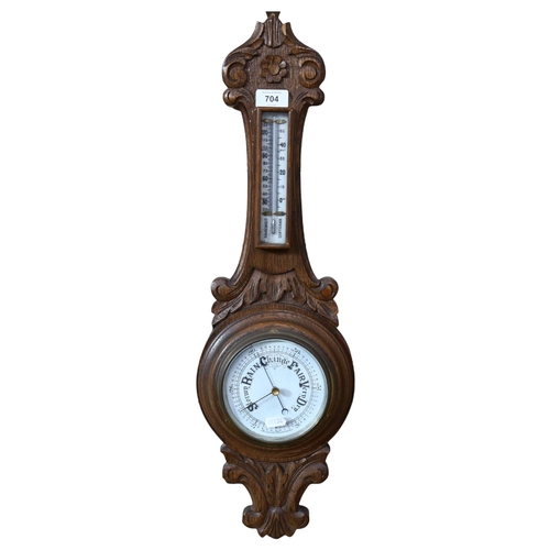 704 - A carved oak-cased aneroid barometer with thermometer, 64cm