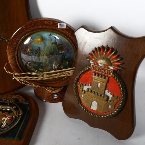 753 - A group of wooden plaques with various Regimental/Nautical badges and crests, a maritime lamp in the... 