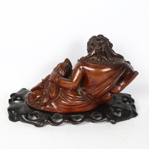 766 - A Chinese hardwood carved Imperial figure, with foo dog, on display stand, L35cm, H23cm, W19cm