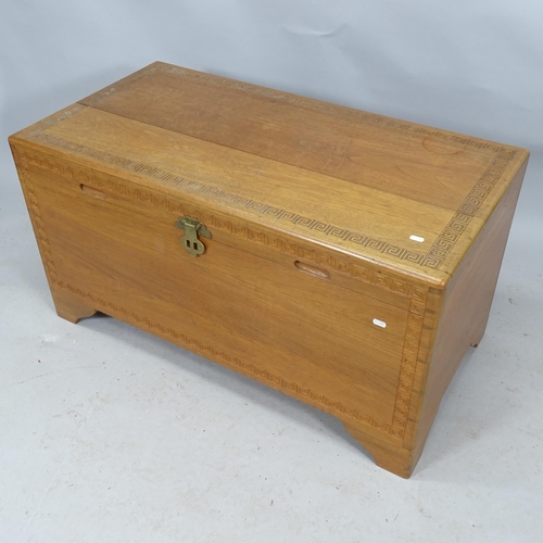 2301 - A Chinese camphorwood blanket chest with carved Greek-key decoration. 107cm x 55cm x 55cm