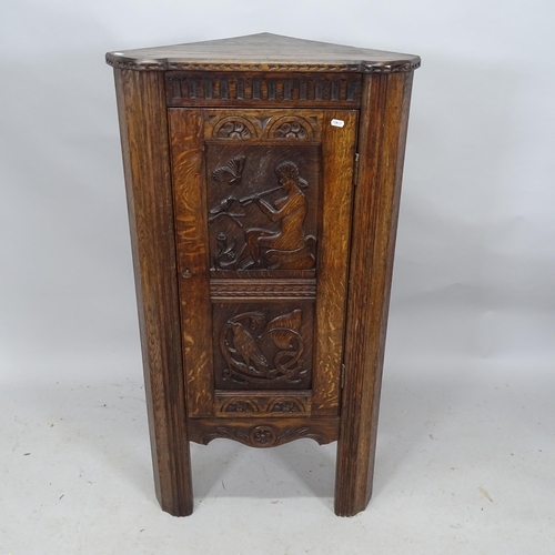 2302 - An oak corner cupboard with single panelled door with applied carved decoration. 63cm x 119cm x 40cm