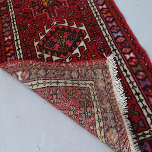 2323 - A red-ground Afghan design runner. 286cm x 63cm