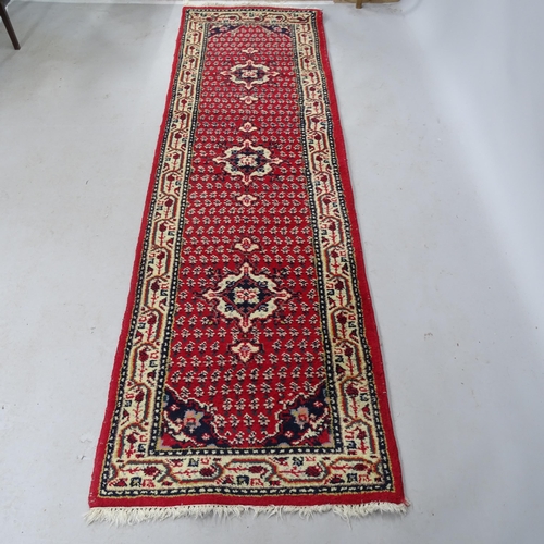 2327 - A red-ground Afghan style runner. 243cm x 72cm