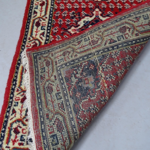 2327 - A red-ground Afghan style runner. 243cm x 72cm