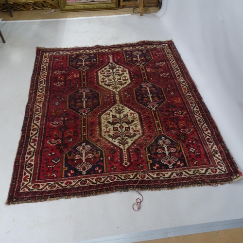 2329 - A red-ground Shiraz design rug. 170cm x 152cm