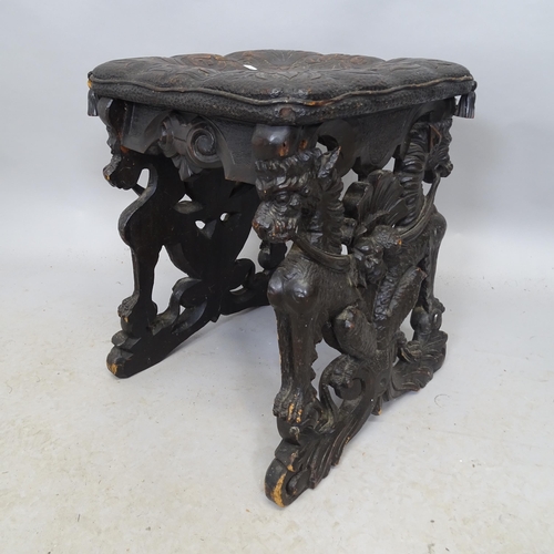 2691 - An antique ebonised carved oak stool with Gryphon and foliate decoration. 41cm x 50cm x 43cm