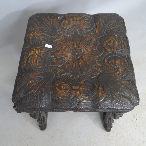 2691 - An antique ebonised carved oak stool with Gryphon and foliate decoration. 41cm x 50cm x 43cm