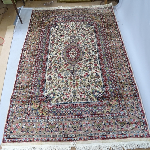 2342 - A red and cream ground Iranian Tabriz carpet with symmetrical floral decoration. 270cm x 175cm