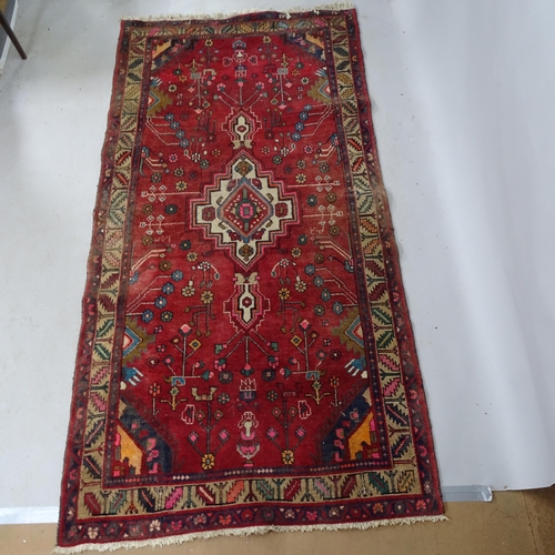 2343 - A red-ground Caucasian rug. 250cm x 127cm