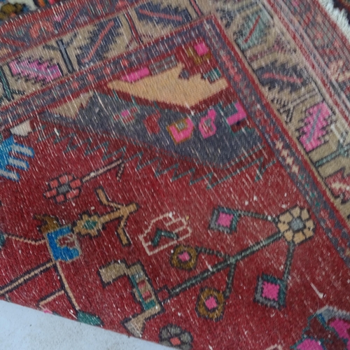 2343 - A red-ground Caucasian rug. 250cm x 127cm