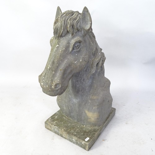 2352 - A heavy carved granite horse's head with attached plinth. H - 66cm.