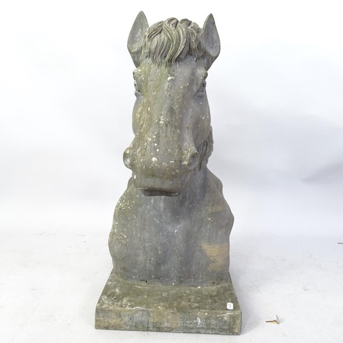 2352 - A heavy carved granite horse's head with attached plinth. H - 66cm.