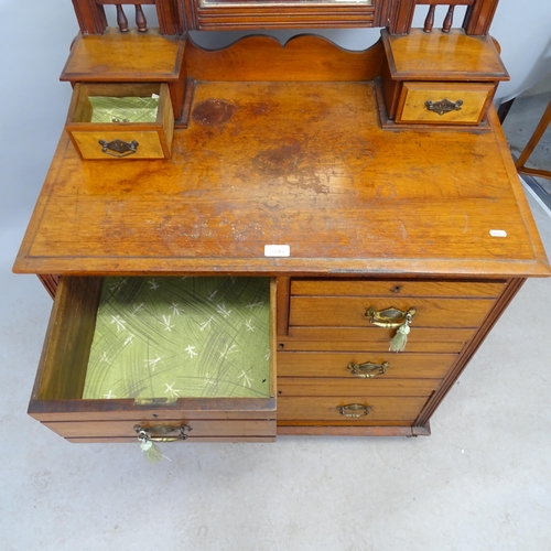 2595 - An Arts and Crafts oak dressing chest with raised back containing two fitted drawers, the chest havi... 