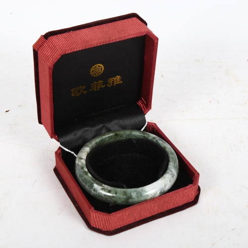 947 - A Chinese green jade bangle, internal diameter 6.5cm, cased