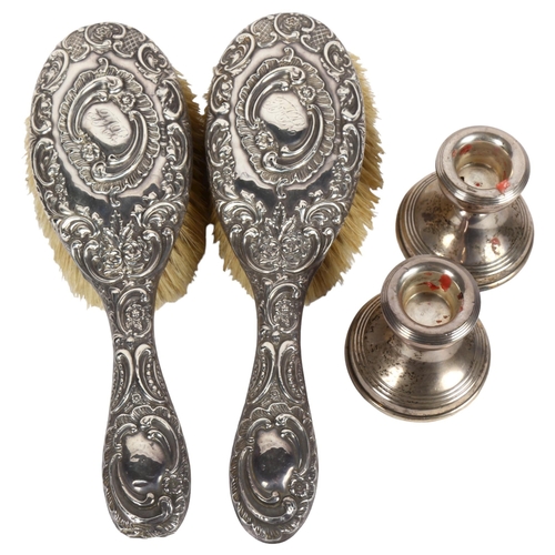 952 - A pair of squat silver candlesticks, and a pair of Art Nouveau silver-backed dressing table brushes