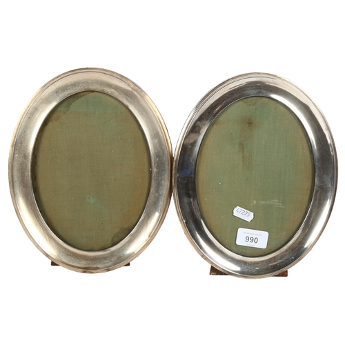 990 - A pair of George V oval silver-fronted picture frames with easel stands