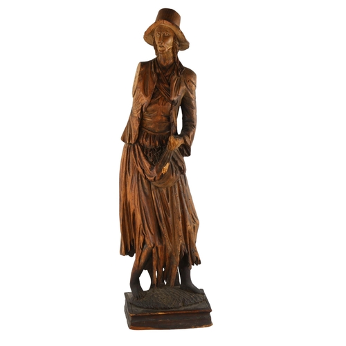 132 - A 19th century carved stained wood figure wearing a hat, height 69cm