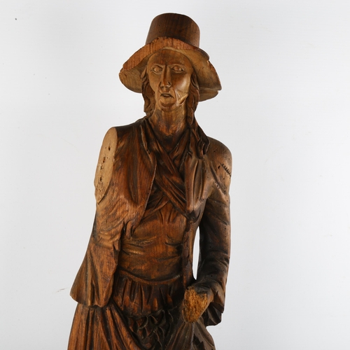 132 - A 19th century carved stained wood figure wearing a hat, height 69cm