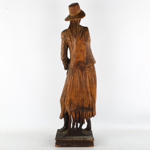 132 - A 19th century carved stained wood figure wearing a hat, height 69cm